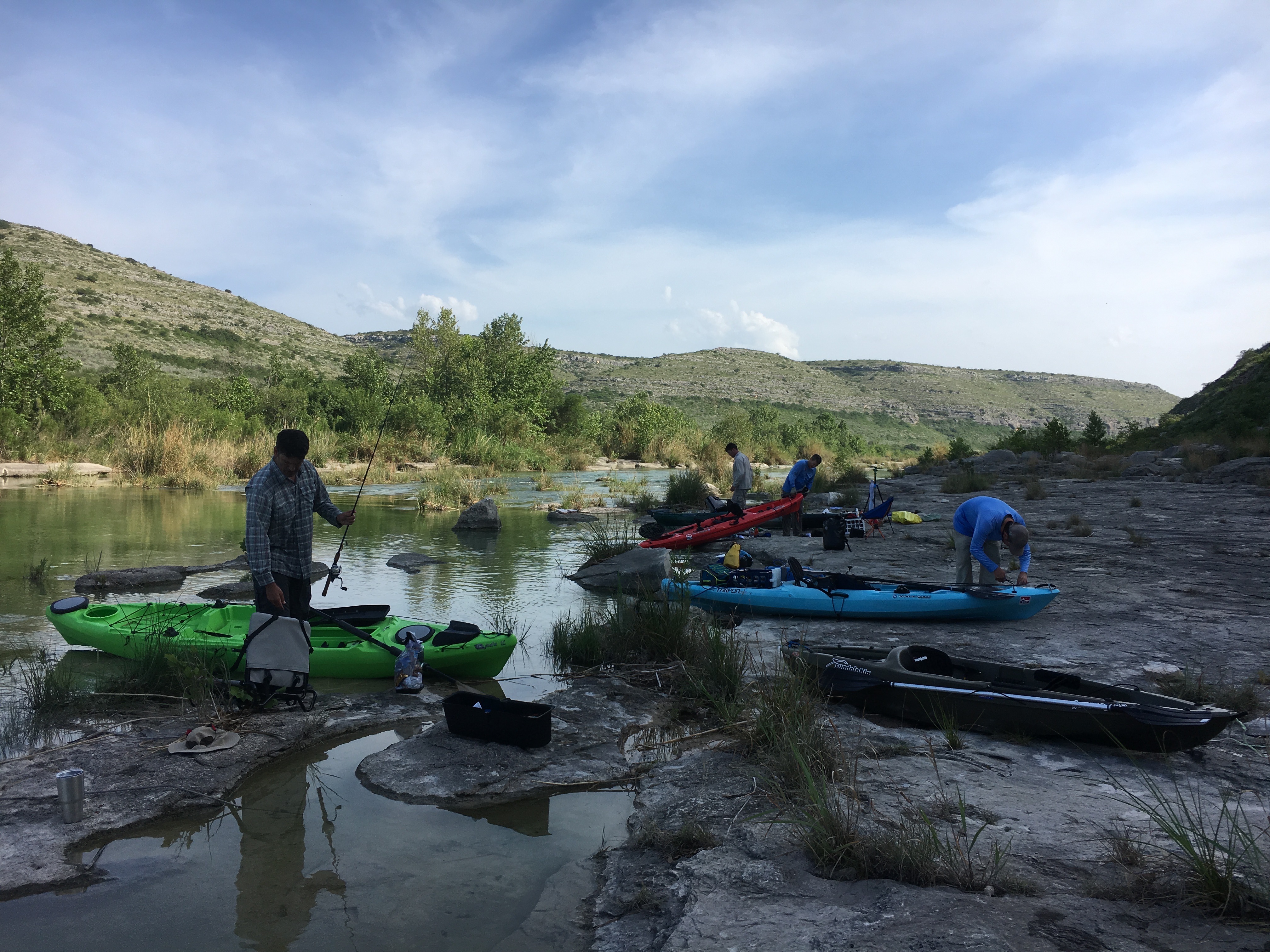 All five of us on the limestone bank — kayaks loaded, fishing rods out, canyon walls behind us