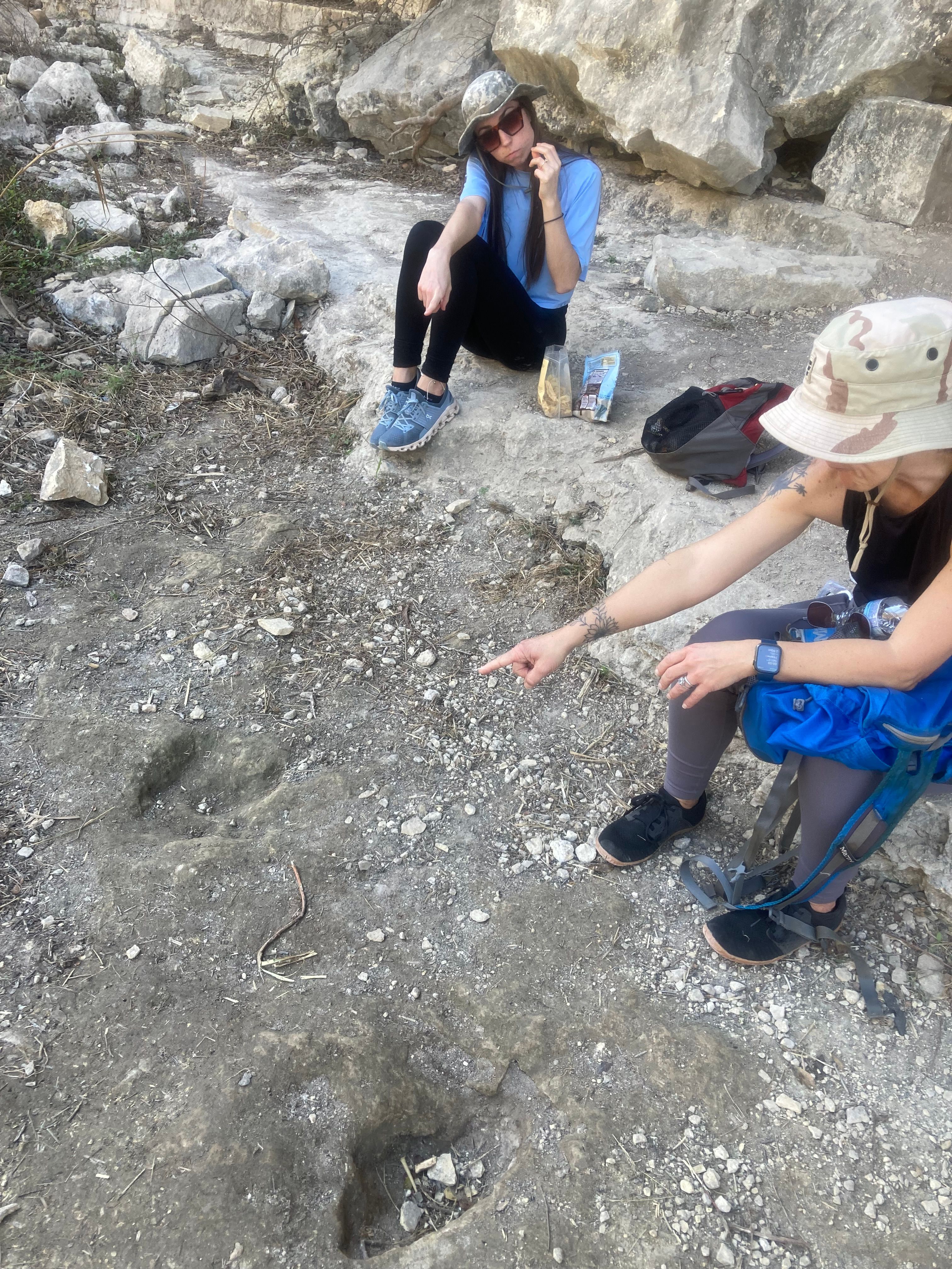 Amy pointing at dinosaur tracks in limestone at Government Canyon State Natural Area, San Antonio Texas